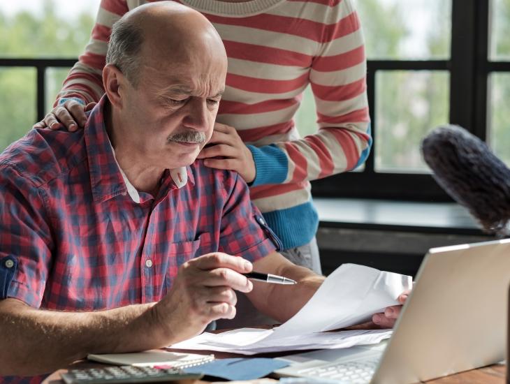 Een man doet de huishoudboekhouding aan tafel