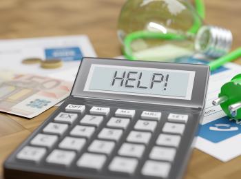 Een tafel met een stekker, euro-biljetten en een rekenmachine met daarop de tekst: Help!